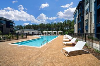 a swimming pool with lounge chairs next to a building at Preston Ridge, North Carolina, 27513